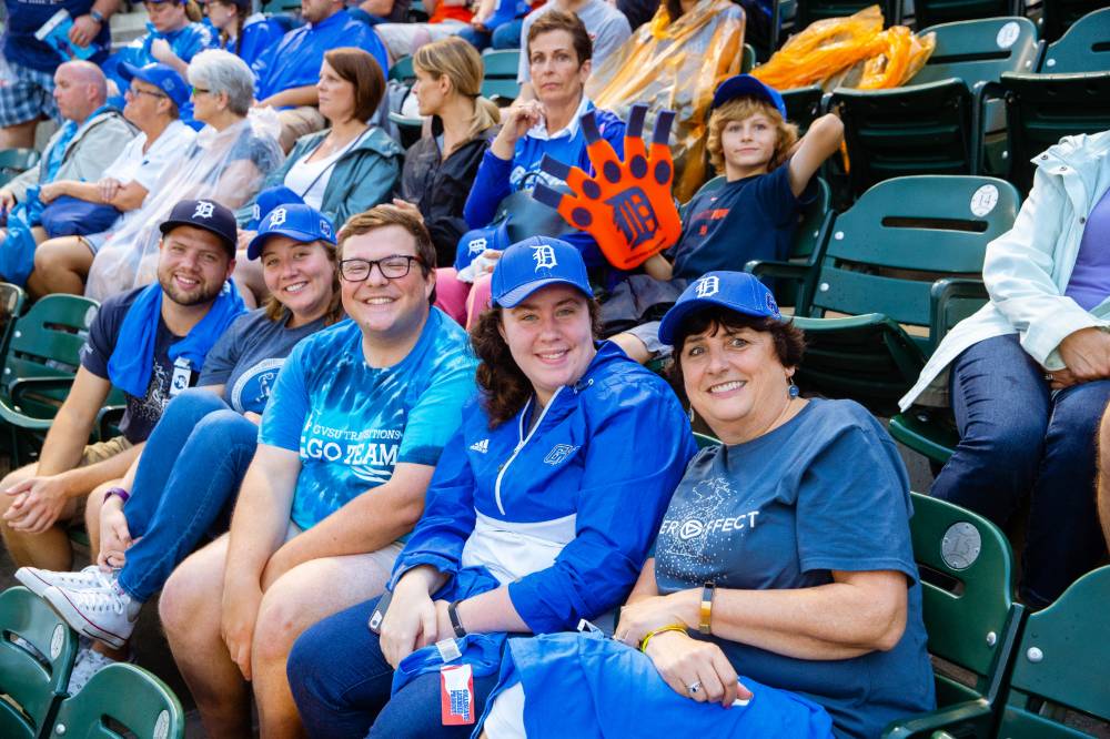 Group photo of 5 in GVSU clothes in the stands of Comerica Park